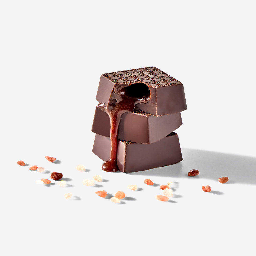 Stack of chocolate pieces with a textured top on a white background
