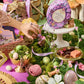 Easter-themed display with chocolate eggs, flowers, and decorative items on a green surface.