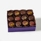 Box of chocolate truffles with decorative toppings on a white background
