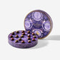 Open purple round tin of Enchanted Magic Chocolate Tower displaying assorted chocolate truffles with colorful toppings.