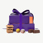 Purple gift box with a bow, cookies, and chocolates on a white background