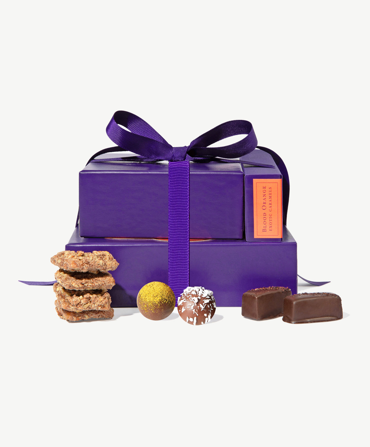Purple gift box with a bow, cookies, and chocolates on a white background