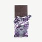 An opened Vosges Manchego and Cherry Chocolate bar in a silver wrapper stands upright on a white background.