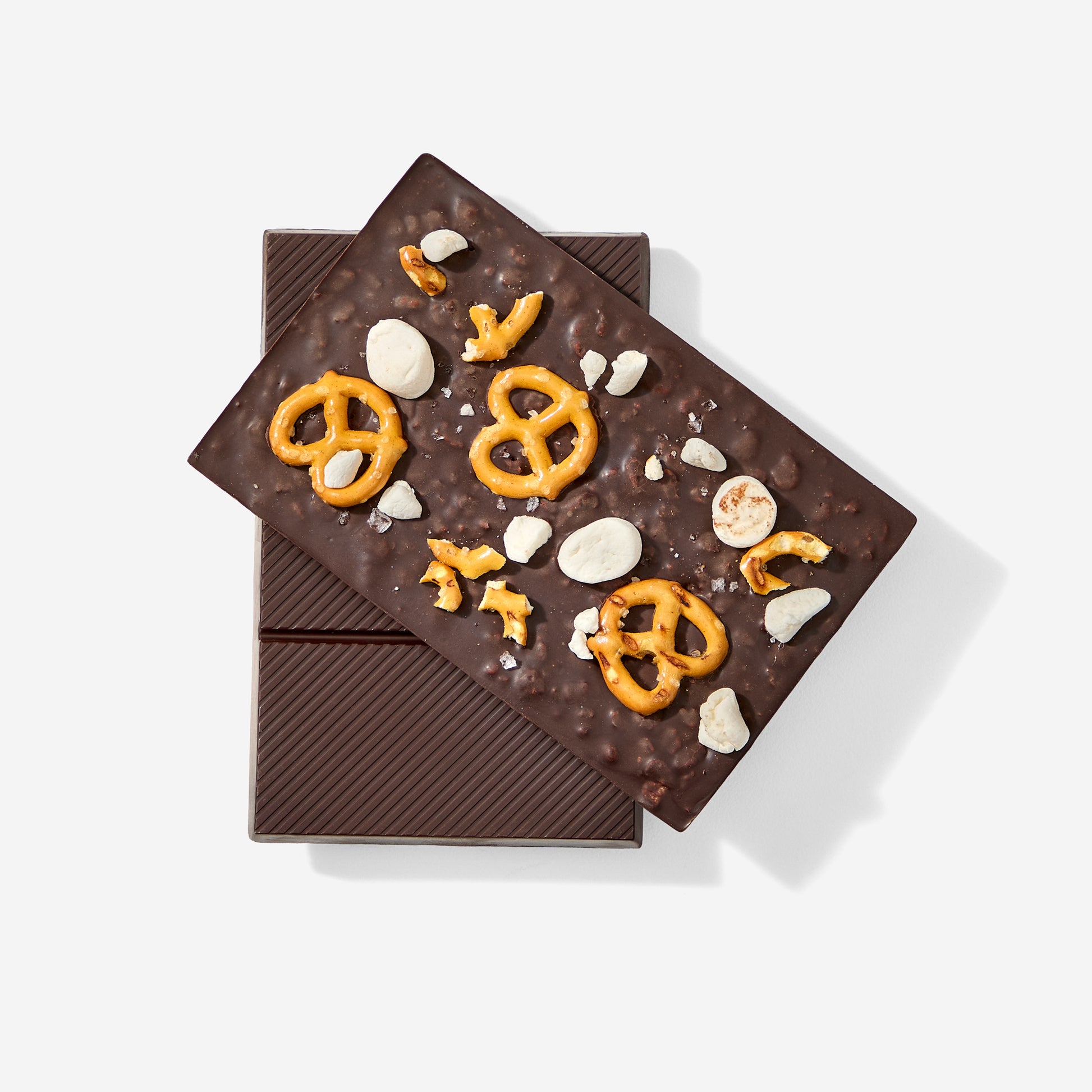 Dark chocolate bar with pretzels and nuts on a white background
